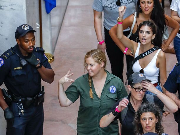 Amy Schumerin takana pidätettyjen joukossa valkoisessa topissa malli-näyttelijä Emily Ratajkowski. 