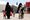 Isis-vaimot kävelevät lastensa kanssa al-Holin leirillä. Kuvituskuva.