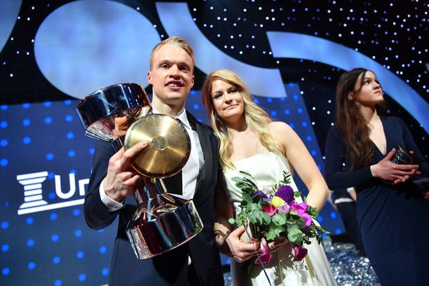 Kolminkertainen vuoden urheilija Iivo Niskanen poseerasi Urheilugaalan lavalla kahden kullan - kiekon ja puolisonsa Saanan - kanssa.
