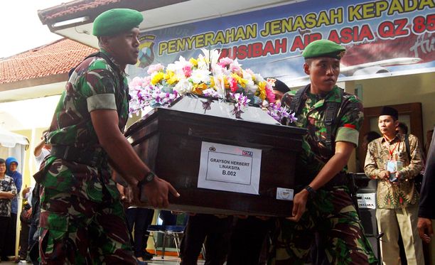 Indonesialaiset sotilaat kuljettavat AirAsian lentoturmassa kuolleen ruumista.