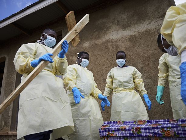 Terveystyöntekijöitä osallistuu ebolaan kuolleen ihmisen hautajaisiin Kongossa Mutwangan kylässä toukokuussa 2019.