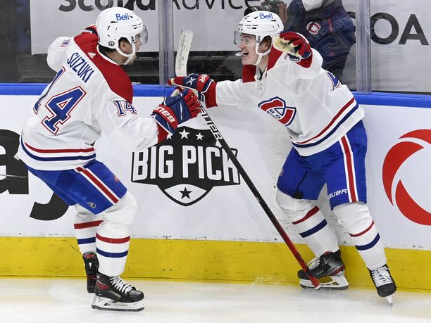 Montreal Canadiensin Nick Suzuki juhlii jatkoaikamaaliaan Cole Caufieldin kanssa.
