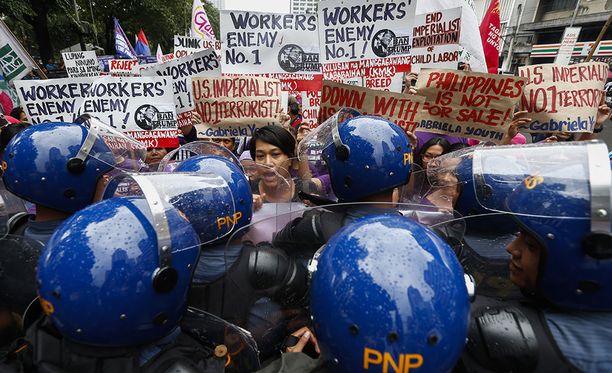 Mellakkapoliisit yrittävät pysäyttää mielenosoittajia Manilassa.