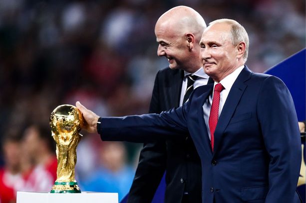 Fifa-pomo Gianni Infantino (vas.) antoi Vladimir Putinin hivellä MM-pokaalia.