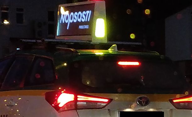 Lukija ihmetteli valokylttiä taksin katolla Tampereella.