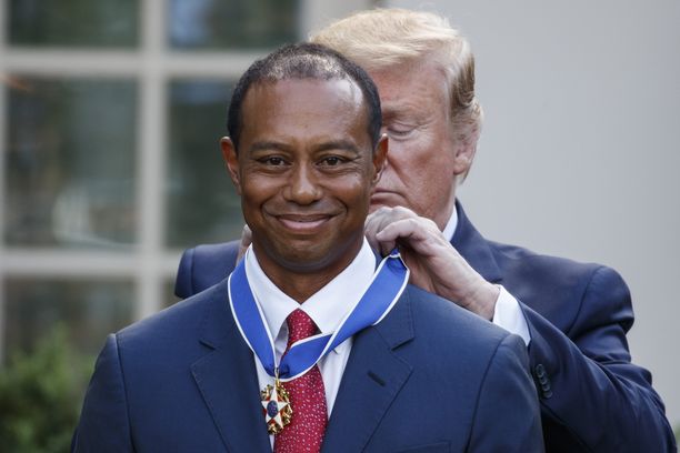 Presidentti Trump kiinnittää Tiger Woodsin kaulaan vapaudenmitalia Valkoisessa talossa järjestetyssä seremoniassa 6.5.2019. 