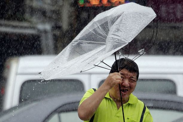 Mies taistelee taifuuni Lekimaa vastaan Taiwanin Taipeissa perjantaina 9. elokuuta 2019.