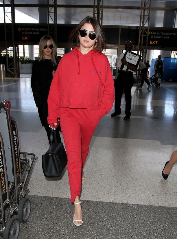 Selena Gomez pukeutui lennolleen rentoon oloasuun. Käsilaukku ja korot tuovat tyyliin ripauksen ylellisyyttä.