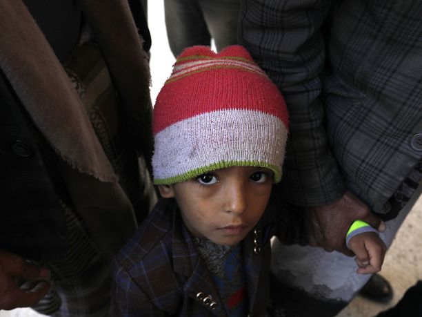 Konfliktien keskellä elävien lasten määrä on noussut rajusti muun muassa Afganistanin, Kongon, Nigerian ja Jemenin tilanteen vuoksi. Kuvassa jemeniläispoika odottaa ruoka-apua isänsä seurassa.