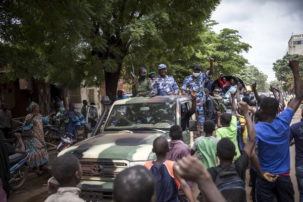 Malilaiset hurraavat sotilaille ja poliisille, kun he ajavat pääkaupunki Bamakon kaduilla 19. elokuuta. 