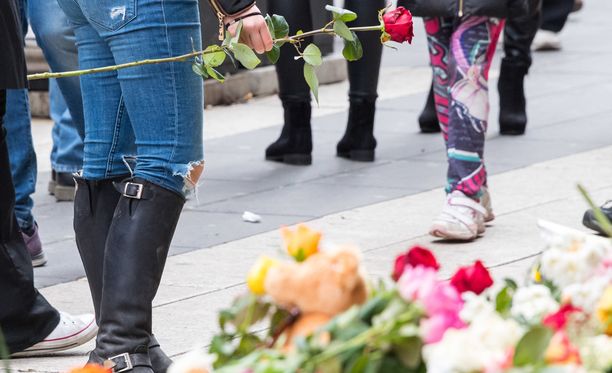 Tukholman Drotninggatanille ohikulkijat jättävät kukkia terrori-iskussa kuolleiden muistoksi.