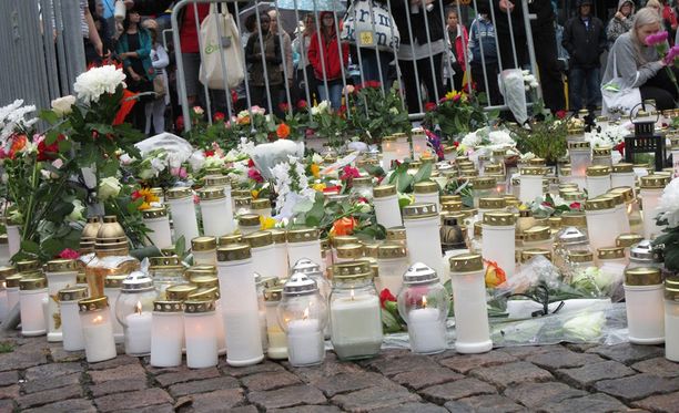 Ihmiset ovat laskeneet kukkia ja kynttilöitä Turun Kauppatorille.