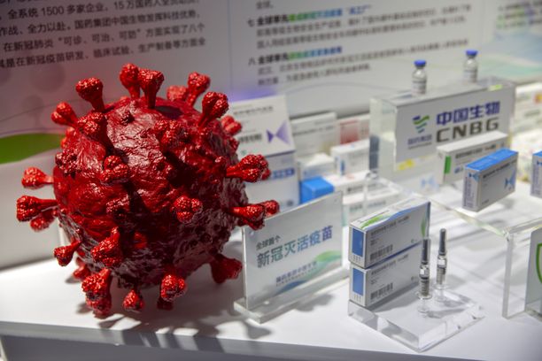 Kiinalaisen Sinopharmin laboratoriossa on näytillä suurennus koronaviruksesta ja valmiita rokotteita sitä vastaan.