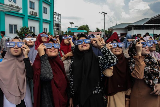 Nuoret naiset kerääntyivät joukolla seuraamaan harvinaista rengasmaista auringonpimennystä Indonesiassa.
