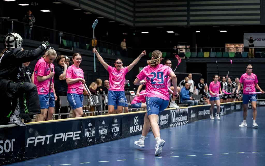 Naispelaajat poseeraavat salibandyseuran mainoksessa ilman yläosia