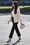 Meghan edusti ME + EM -merkin jakussa, mustissa housuissa ja sievissä korkkareissa. Rejina Pyon laukku tuo asuun trendikkään lisän. 