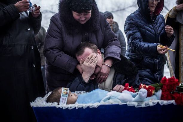 Vladimir Bovrichev, 30, itki poikansa Artiamin, 4, arkun äärellä viime viikolla. Artiam kuoli tykistöiskussa lähellä Donetskia.