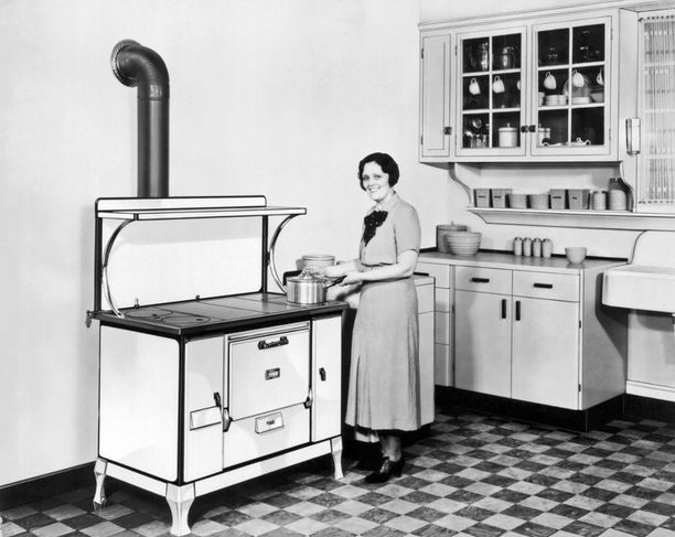 Vuoden 1928 keittiön ilmettä hallitsi iso liesi. Kuvassa yhdysvaltalainen nainen ruuanlaittopuuhissa.