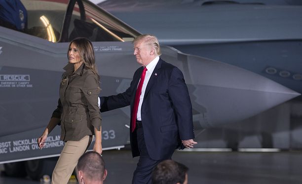 Donald Trump kävelemässä F-35 -hävittäjän editse Andrewsin lentotukikohdassa Marylandissa vaimonsa Melanian kanssa. Trump on syyttänyt koneita liian kalliiksi.