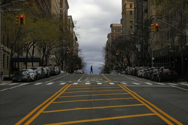 Mies ylittämässä katua koronaviruksen autioittamassa New Yorkissa perjantaina.