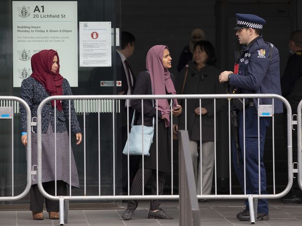 Uuden-Seelannin moskeijaiskun uhrin omainen keskustelee poliisin kanssa tuomioistuimen ulkopuolella Christchurchissa.