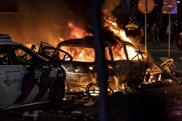 Autot paloivat Rotterdamin yössä perjantaina, kun koronarajoituksia vastustaneet mellakoitsijat ottivat yhteen poliisien kanssa. 