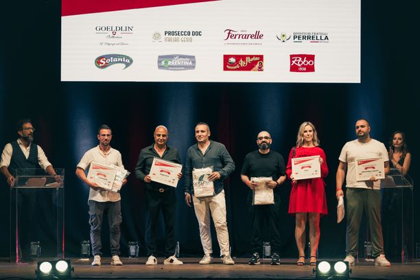 Viiden pizzerian edustajat nousivat lavalle kerrallaan noutamaan palkinnon Napolissa 7.9.2022. Kuva: Alessandra Farinelli
