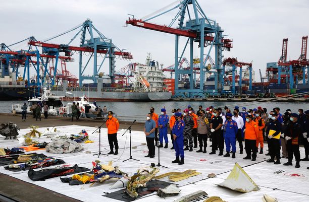 Pelastustyöntekijät esittelivät merestä löytyneitä turmakoneen osia Jakartassa maanantaina. 