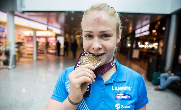 Iltapäivällä Helsinkiin saapunut Euroopan mestari Petra Olli esitteli kultamitaliaan lentoaseman rahanvaihtopisteen edessä.