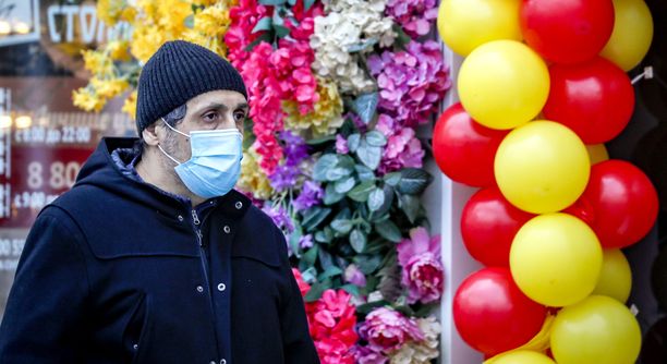 Moskovalainen mies käyttää maskia kävellessään ostoskadulla. 