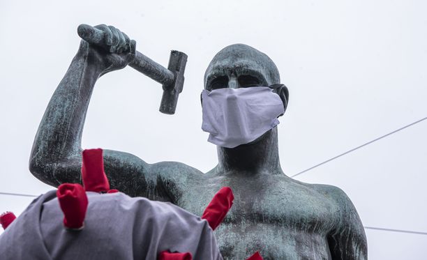 Helsingissä Kolmen sepän patsas puettiin maaliskuussa hengityssuojaimiin.
