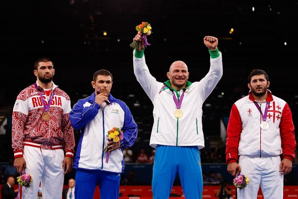 Artur Taimazov (toinen oikealta) tuuletti olympiakultaa, mutta saavutus hylättiin viime vuonna. Myös hopeamitalisti Davit Modzmanashvili (oikealla) diskattiin dopingkäryn vuoksi. Uusia olympiavoittajia ovat kolmanneksi sijoittuneet Komeil Ghasemi ja Biljal Mahov. 