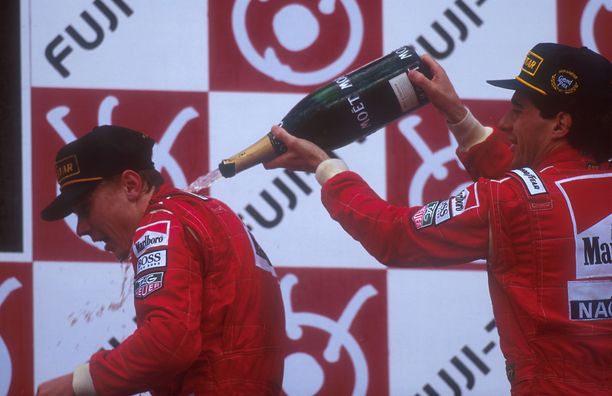 Kisan voittanut Ayrton Senna kaatoi samppanjaa Mika Häkkisen niskaan Japanin osakilpailun palkintopallilla lokakuussa 1993.