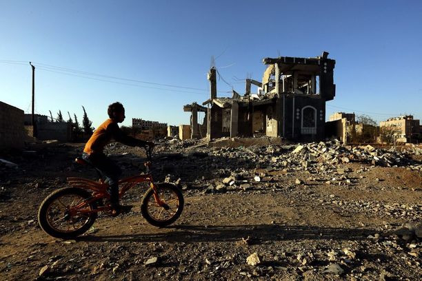 Poika pyöräili ilmaiskussa tuhotun rakennuksen ohi viikonloppuna pääkaupunki Sanaassa.