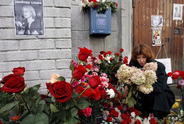 Nainen asetti kukkia Politkovskajan kotitalon eteen Moskovassa päivä murhan jälkeen, 8. lokakuuta vuonna 2006. 