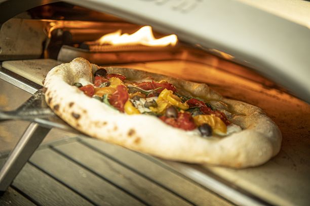Napolilainen pizza paistuu kuumassa uunissa ja pohja on pehmeä.