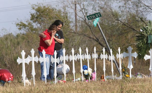 Ihmiset itkivät Texasin Sutherland Sprinsin uhrien muistoksi pystytettyjen ristien äärellä tiistaina.