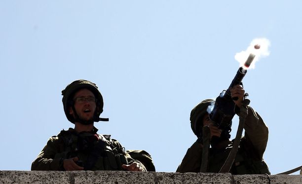 Israelin ja Palestiinan välillä levottomuudet ovat jälleen yltyneet. Kuvassa israelilaissotilas ampuu kyynelkaasukranaatin mellakoiden aikana Hebronissa.