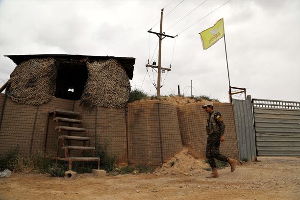 Kurditaistelija käveli tukikohdan ohi maaliskuussa. Kurdit ilmoittivat vallanneensa Isisin viimeisen linnakkeen 23. maaliskuuta 2019. 