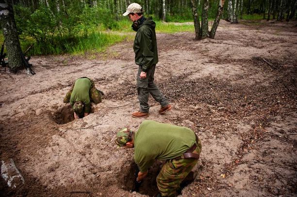 Varusmiehet näyttivät elokuussa 2012 puolustusministeri Carl Haglundille (r), kuinka poteroja kaivetaan.