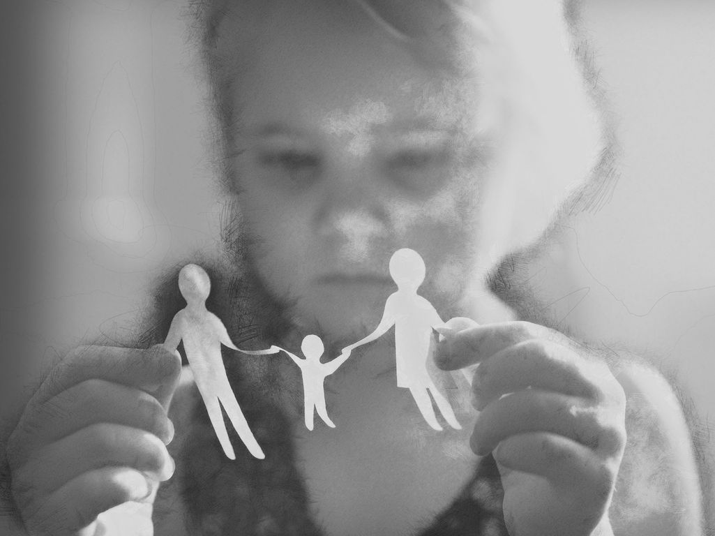little girl with paper family in hands. concept of divorce, custody and child abuse