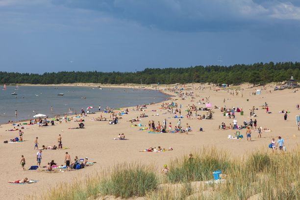 Ihmiset ottavat aurinkoa Yyterin uimarannalla Porissa kauniina kesäpäivänä. 