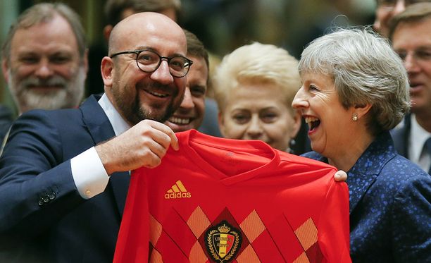 Theresa May innostui belgialaislahjasta. Nähtäväksi jää, onko paita päällä, kun Englannin leijonat kohtaavat Belgian MM-jalkapallossa.