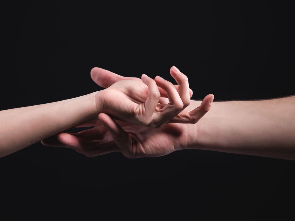 A close-up of two hands male and female gently touch each other. The concept of tremulous rejection between the sexes. Warm relations between men and women